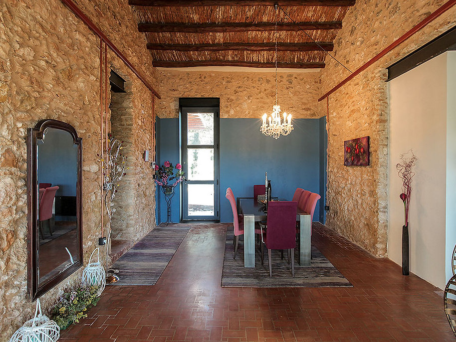 Comedor rústico con vigas de madera vistas y muros de ladrillo cocido